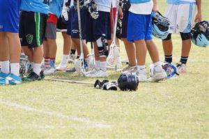 A boys lacrosse team standing in huddle